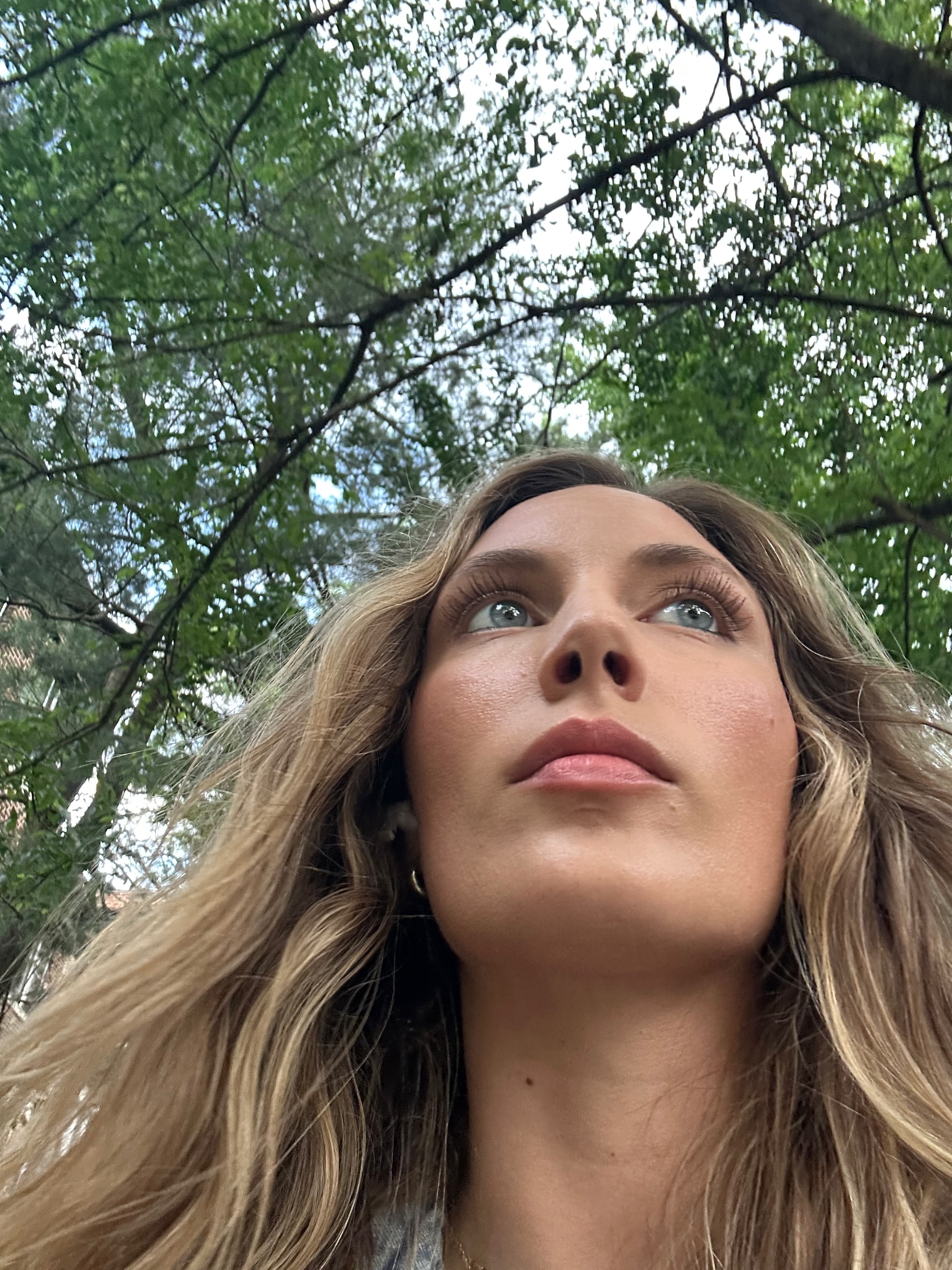 Jordan Maher looking up at trees during a nature walk